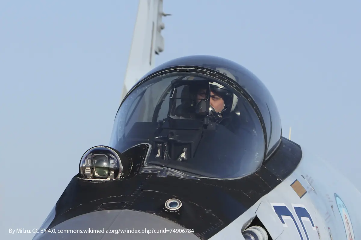 Close-up view of a IRST on a fighter jet cockpit with the pilot visible inside the transparent canopy.